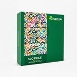 A 500-piece jigsaw puzzle box by Puzzlers, featuring a vibrant multicolor Arabic calligraphy design on the front cover and a solid green side panel.
